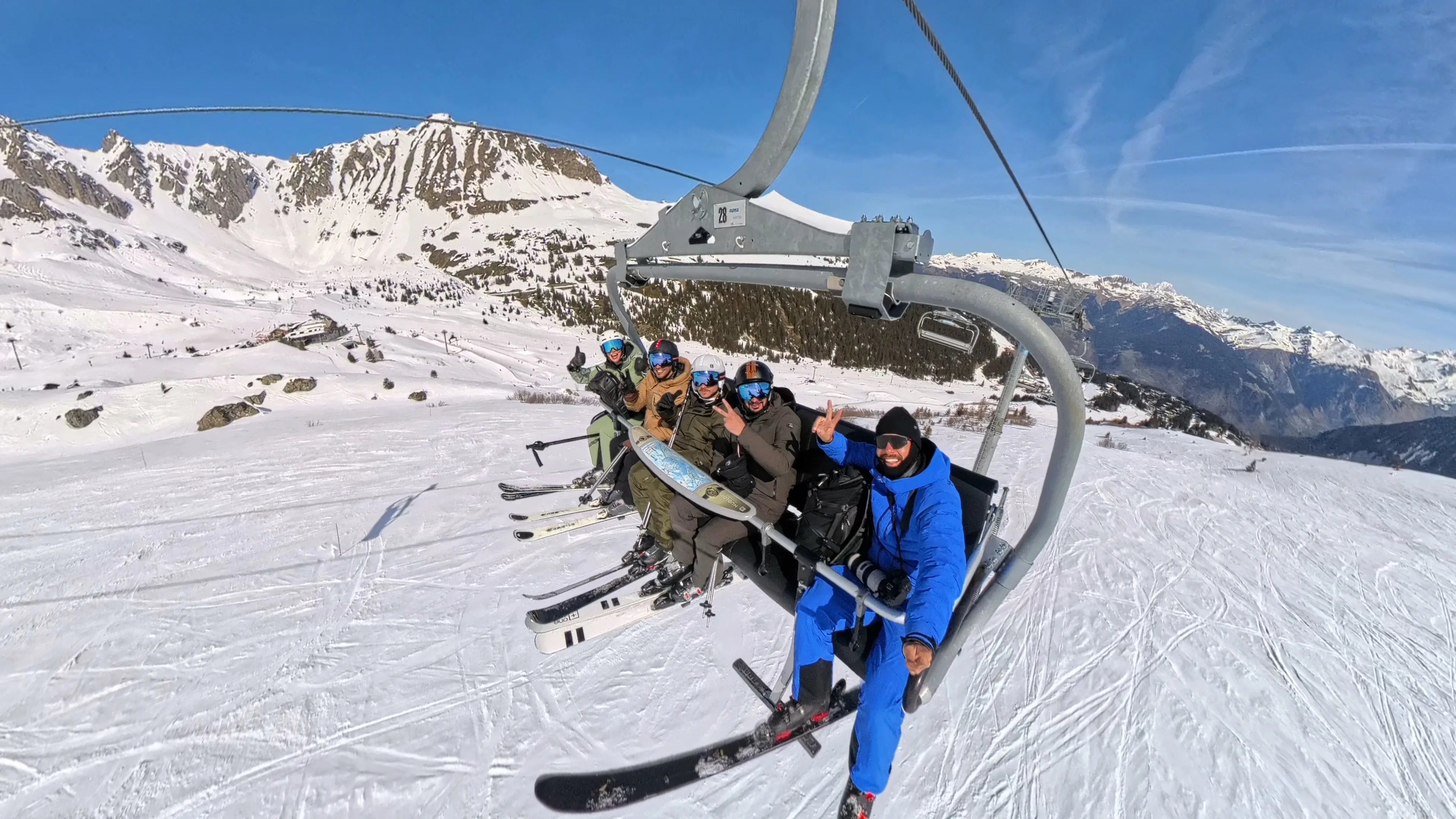 Courchevel Media photographer riding a chairlift with clients during a ski holiday in Courchevel.